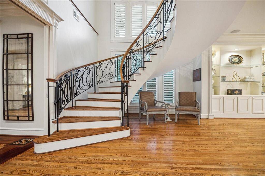 The striking floating, curved staircase serves as a stunning architectural centerpiece, elegantly connecting the first and second levels of this luxury home. Its graceful design blends seamlessly with the home's refined aesthetic, creating a sense of flow and sophistication.