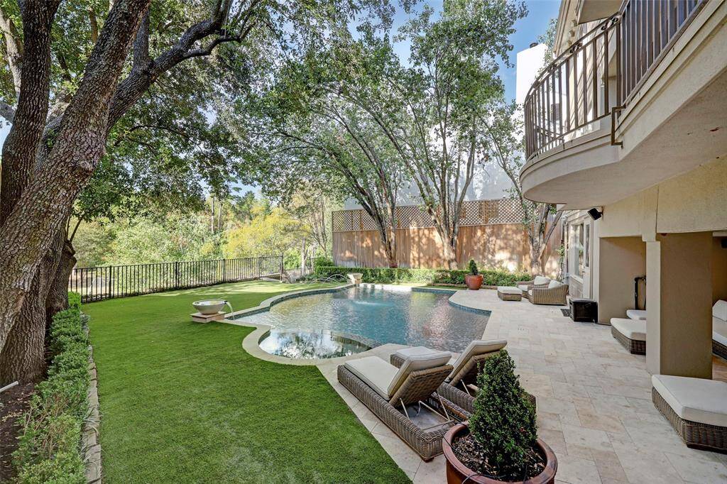 This luxurious backyard boasts a heated pool and spa with tranquil fountain features, offering stunning views of the lush, natural landscape. A covered patio overlooks the pool, providing a perfect space for outdoor relaxation, while two exterior balconies and the lush, year-round artificial turfed lawn enhance the area’s appeal for entertaining. Complete with exterior cameras for added security, this backyard seamlessly blends beauty, function, and privacy.