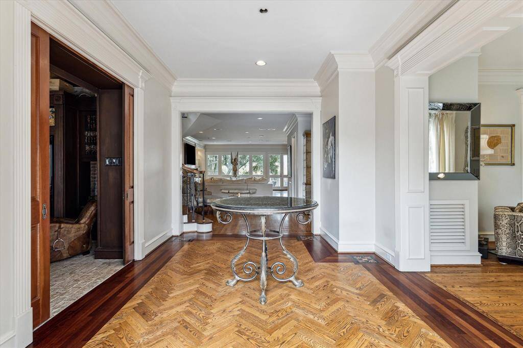 A floating, curved staircase gracefully leads to the second level, enhancing the entry’s architectural charm. Pocket doors offer privacy between the front of the home and the family room, while an Inclinator elevator with a 500 lb capacity provides effortless access throughout the home. Every detail in this sophisticated entry exudes timeless luxury.