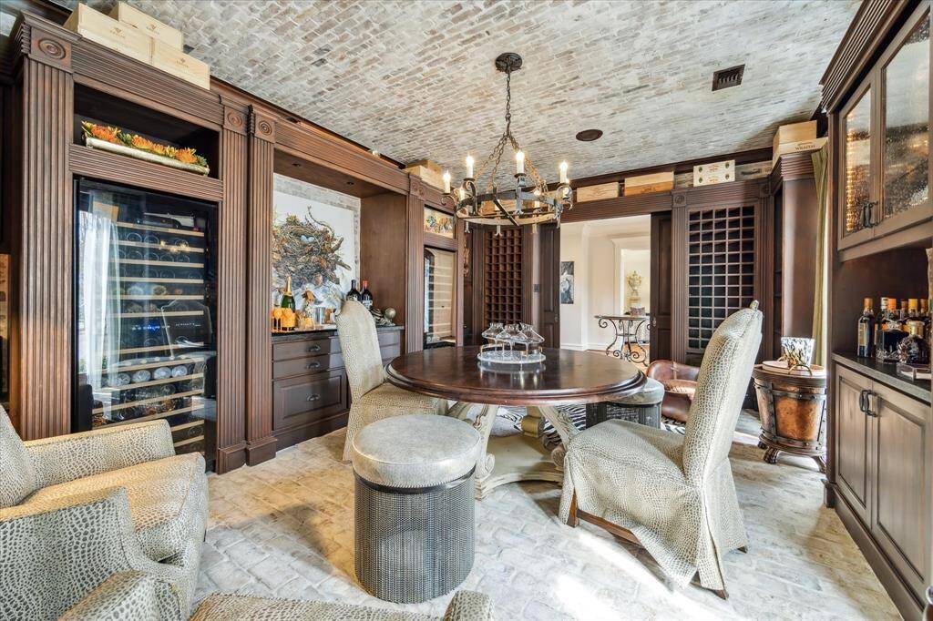 The room also includes dual Nfinitywine refrigerator towers for optimal wine storage, ensuring every bottle is kept at the perfect temperature. In- ceiling speakers enhance the experience, making it an ideal space for hosting tastings or intimate gatherings. This luxurious wine room perfectly blends old-world charm with modern convenience.