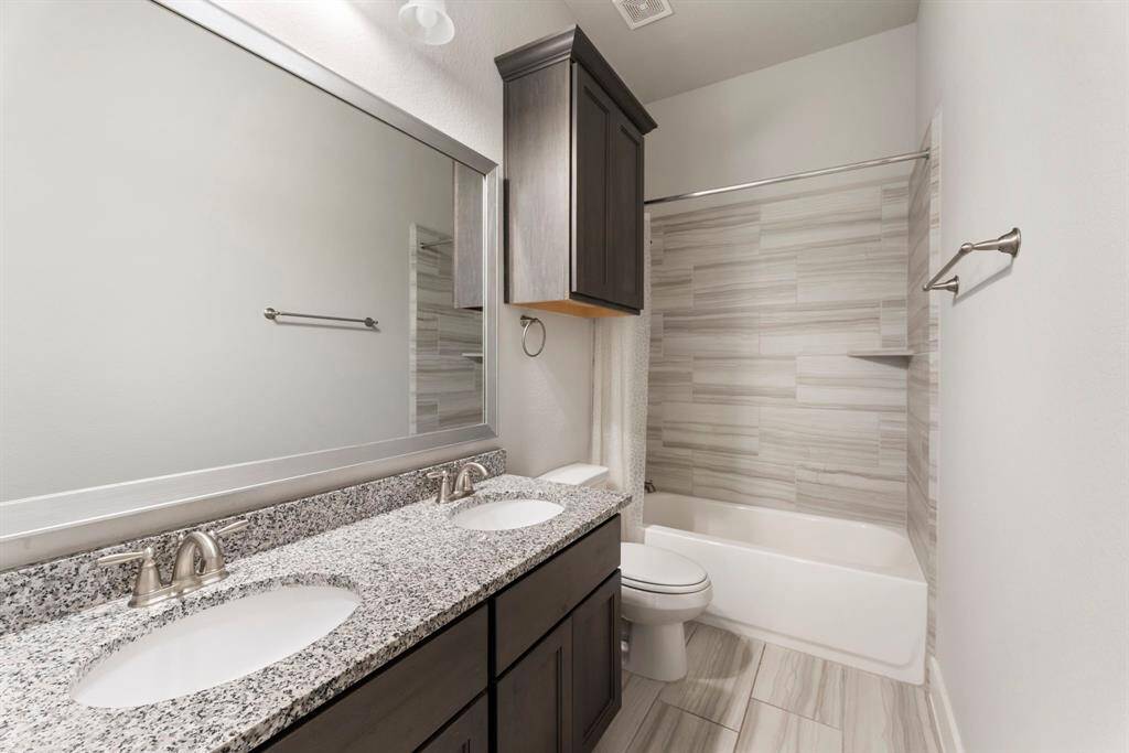 Secondary batroom has double sinks.