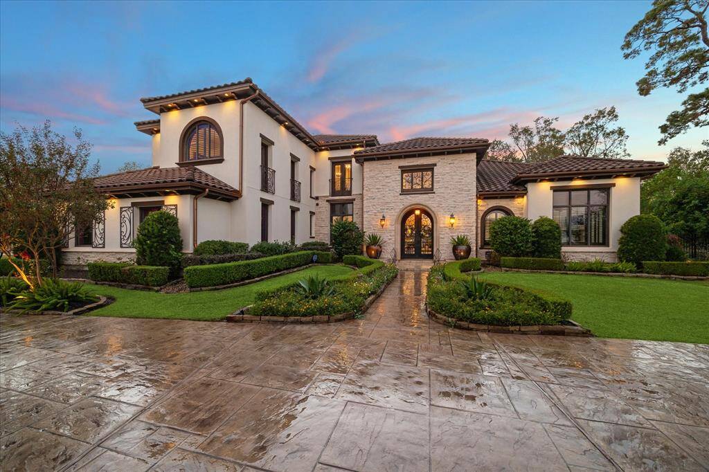 The landscaping received an extensive 'refresh' in preparation for the Garden Club tour. The well manicured gardens include a symmetrical design with hedges and flowering  plants, leading up to a welcoming walkway.