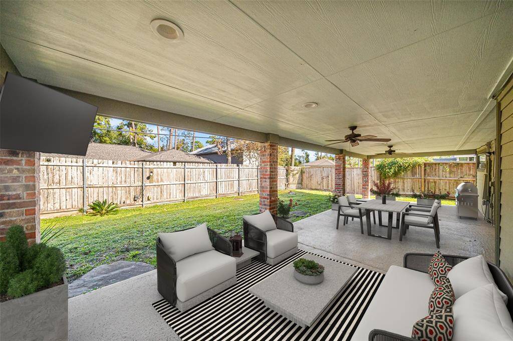 The expanded, covered and recently added epoxy flooring makes this outdoor patio space perfect for family events, or friend gatherings, offering a picturesque setting for outdoor enjoyment - Virtually Staged