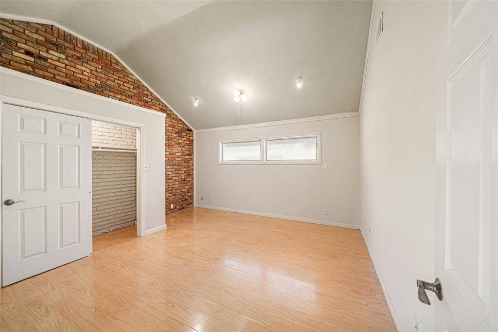 Originally an open and unused space, the owners have transformed this into an extra bedroom while preserving it's original elements of the prick accent wall and vaulted ceilings.