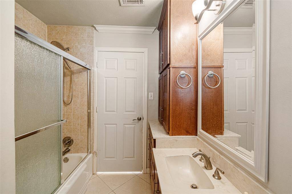 The secondary bathroom features a tub/shower combo with plenty of storage for linens and toiletries.