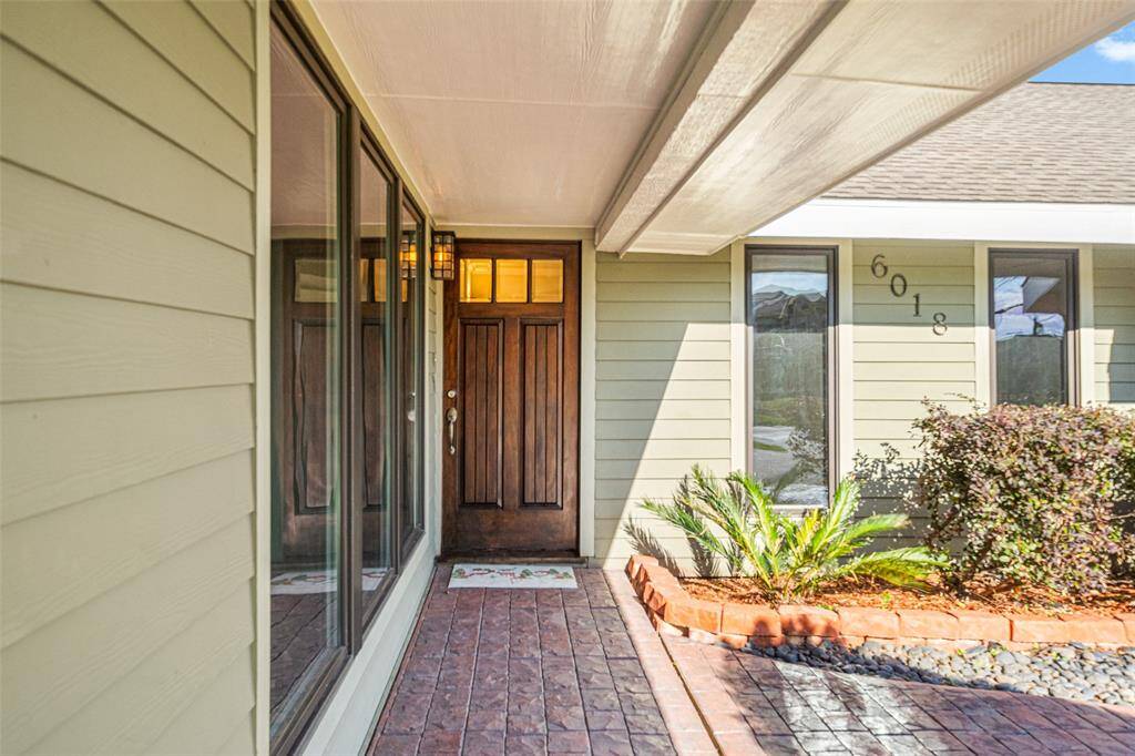 As you walk up you are greeted by a handsomely appointed front door and stamped concrete under an oversized covered walkway.