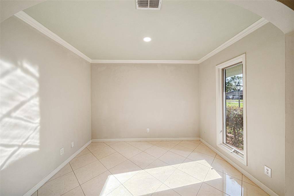 Adjacent to the kitchen the dining room looks out onto the lush grounds and front drive. The oversized window allows for natural light to illuminate the space.