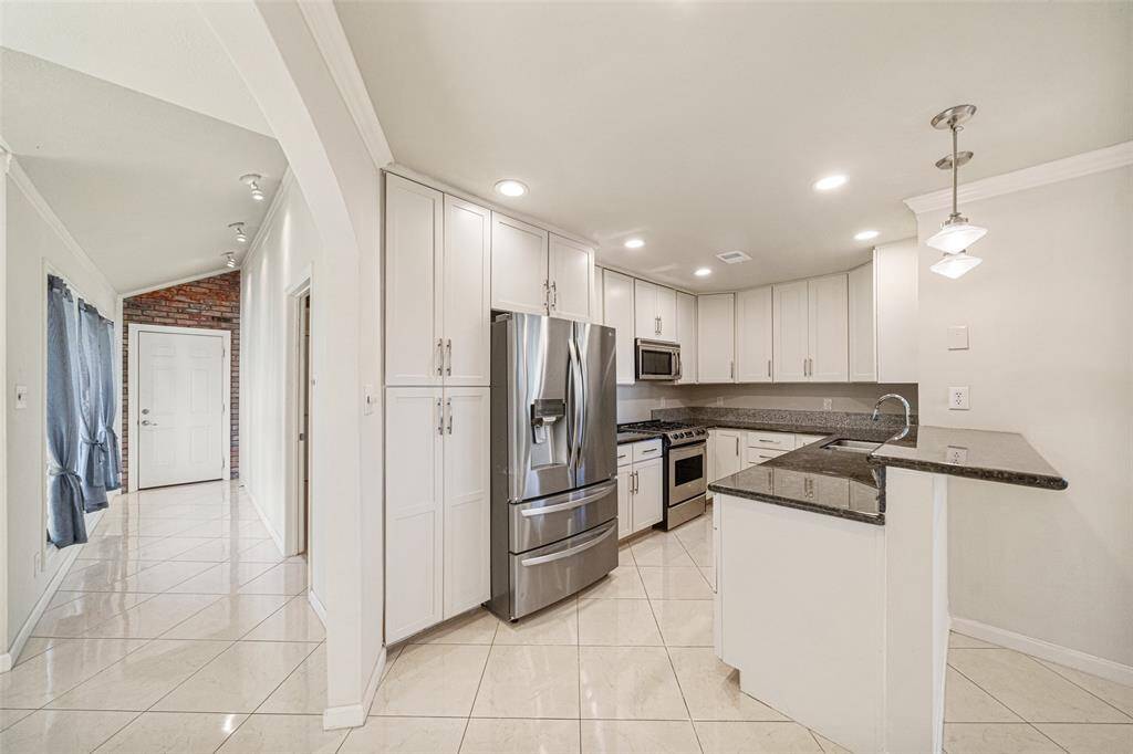 Completely redone, the kitchen is the heart of the home with sleek tones and well appointed cabinetry.