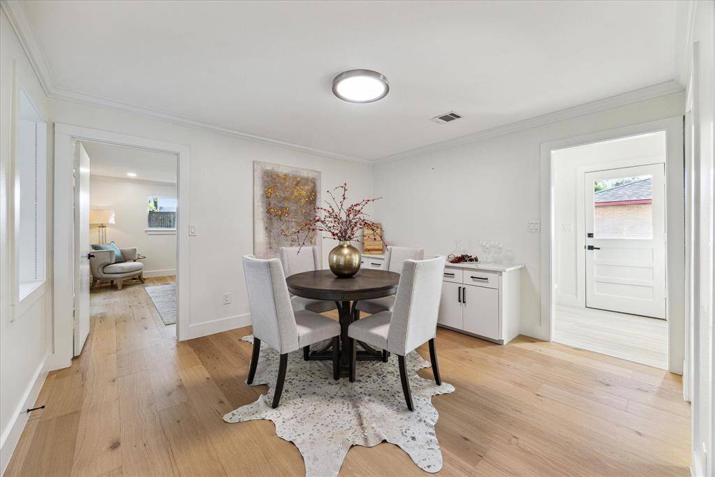 A spacious eating area off the kitchen leads out onto the back deck and pool. The utility room is also nearby with the primary suite in close proximity.