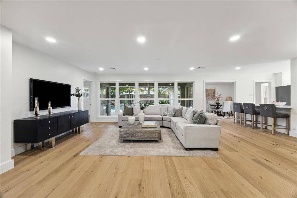The living room is framed by five large picture windows looking out onto the back deck and pool area. Breakfast bar and kitchen off the living room create an ideal space for relaxing or entertaining guests.