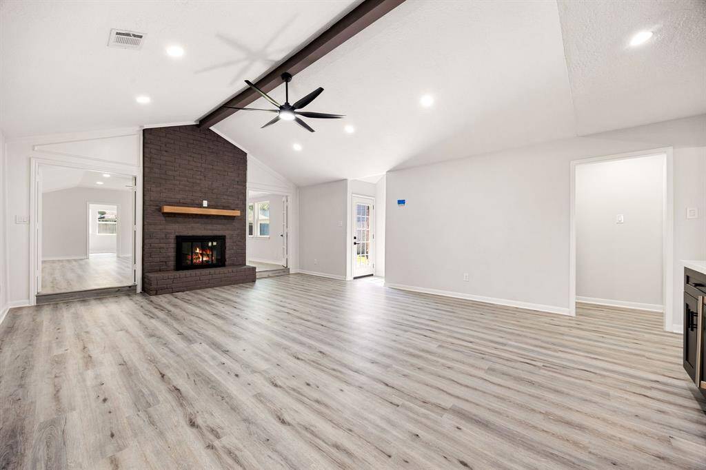 Spacious sunken living room with fireplace, wood beams, modern living room.