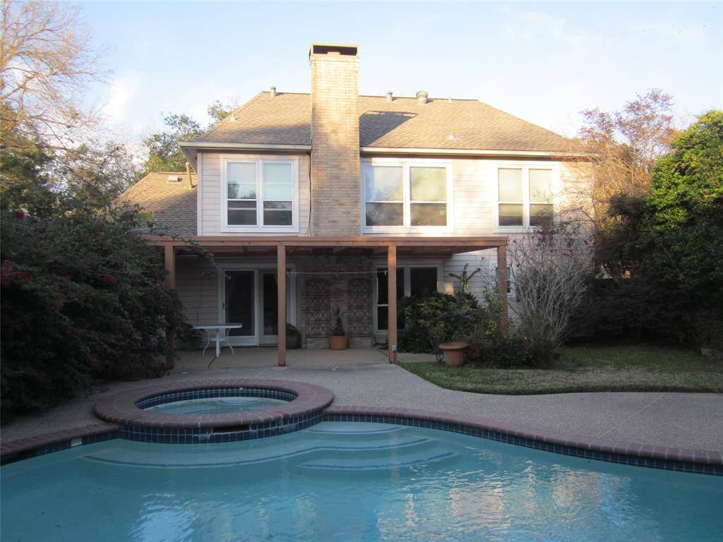 Serene backyard with heated pool and hot tub, covered back patio