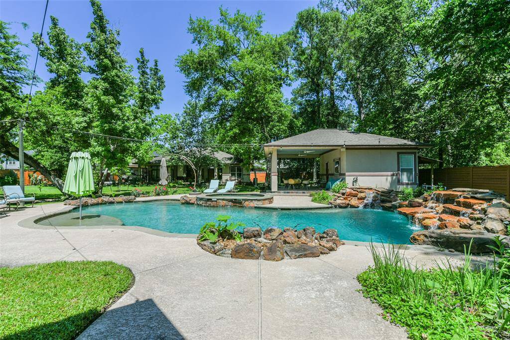 Live a STAYCATION every day within your own private compound.  Enjoy beautifully landscaped acreage with stunning waterfall pool, guest house, and second home for family members or a friend.  This is pretty much a one of a kind like this in our Houston area!