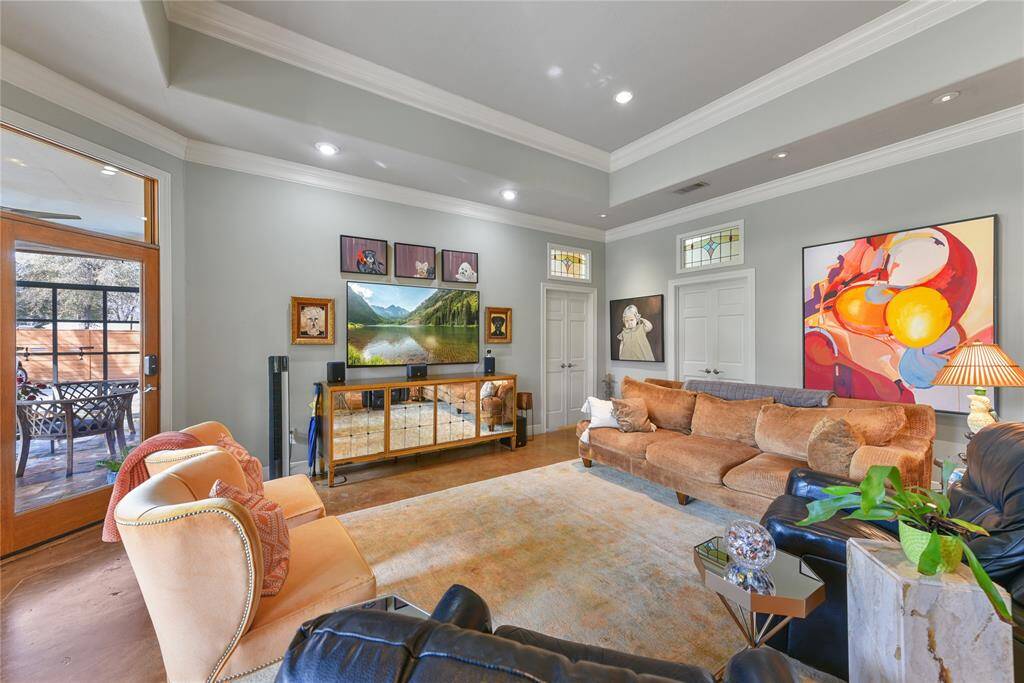 The living area of the second home is ultra spacious with ceilings up to 12ft.  Stained concrete flooring, recessed and art lighting throughout make this home special.  Note the detail of the antique stained glass window transoms above the doorways.