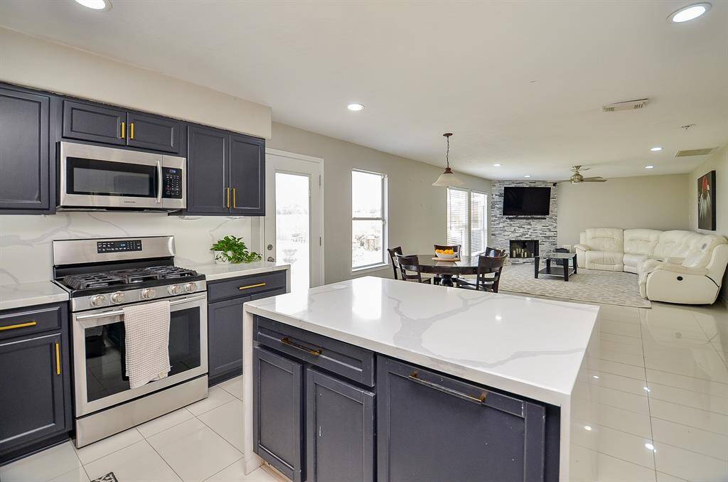 The dark cabinetry offers a striking contrast against the light-colored backsplash and countertops