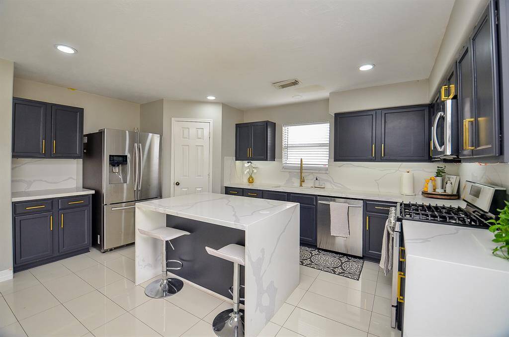 The state-of-the-art stainless steel appliances, including an oven, microwave, and refrigerator, ensure that all your cooking needs are met with ease and efficiency.
