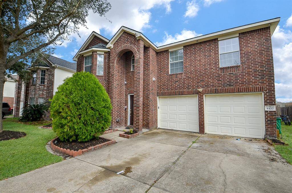 The wide driveway and two-car garage provide ample parking space for your convenience.