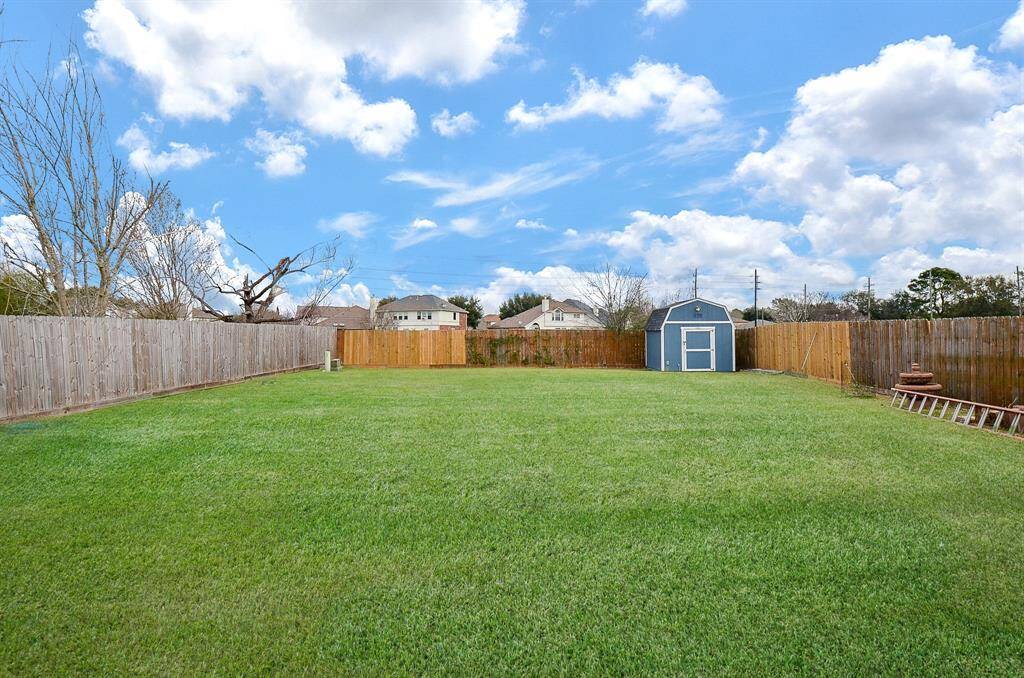 The yard is enclosed by a charming wooden fence, ensuring both privacy and a touch of rustic elegance.