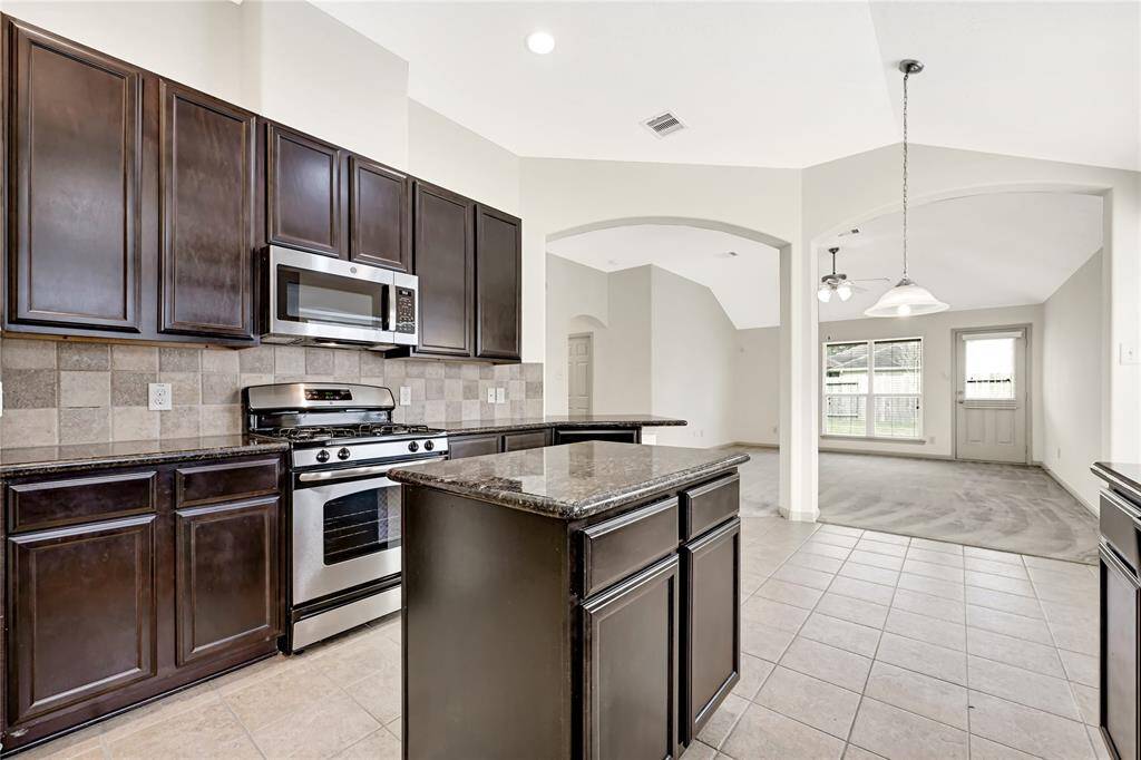 Look at the beautiful tile and granite combination that adorns this large kitchen with plenty of storage space. The beautiful sloped ceiling and archways add a timeless classiness to this home.