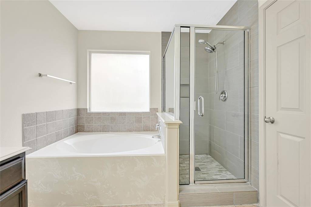 The primary bathroom comes with a large soaking tub and separate beautifully tiled shower.