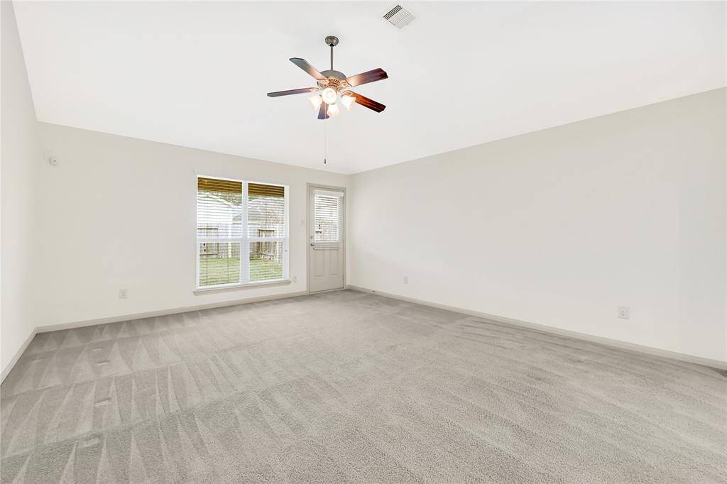 This living space is so grand and leads to the back covered patio.