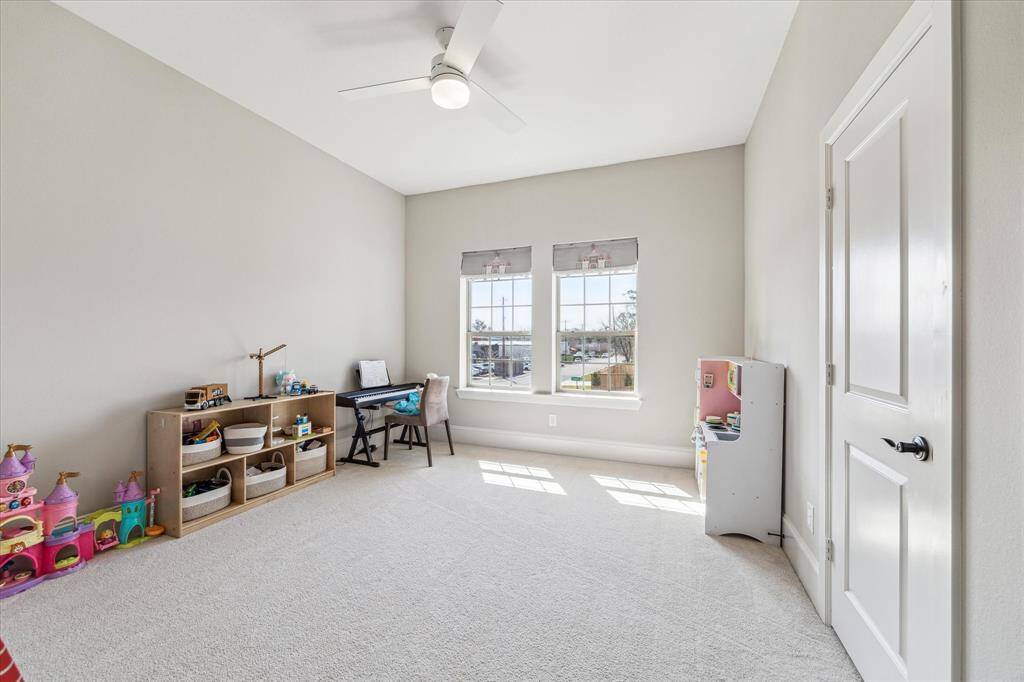 This secondary bedroom offers a flexible layout with plush carpeting, high ceilings, and oversized windows that bring in natural light. Neutral tones create a serene atmosphere, while the generous space allows for multiple uses, from a playroom to a guest suite or home office. Positioned on the second floor, this room provides a quiet retreat within the home.