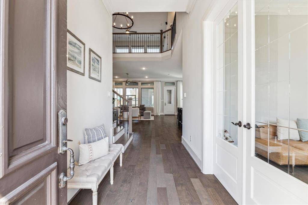 A grand two-story foyer welcomes you into this stunning David Weekley home in Oak Forest. Glass-paneled French doors open to a private home office, while the open-concept layout seamlessly connects the main living spaces. Thoughtful architectural details, including soaring ceilings and a sleek iron staircase, enhance the home’s spacious and inviting atmosphere.