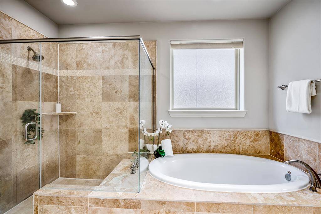 A closer look at the tub and stand-up shower, which includes a utility shelf and bench seating.