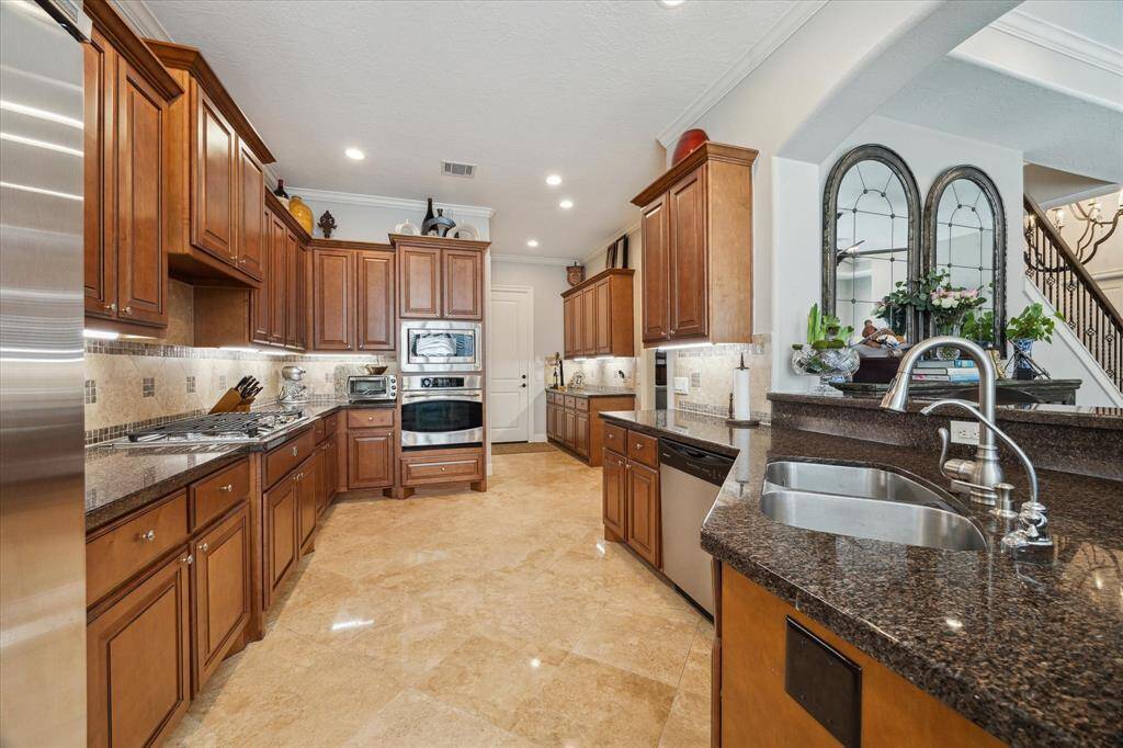 GOURMET KITCHEN WITH BUILT-IN STAINLESS APPLIANCES - granite counters, under-cabinet lighting, beautiful travertine flooring, large walk-in pantry (not shown)
