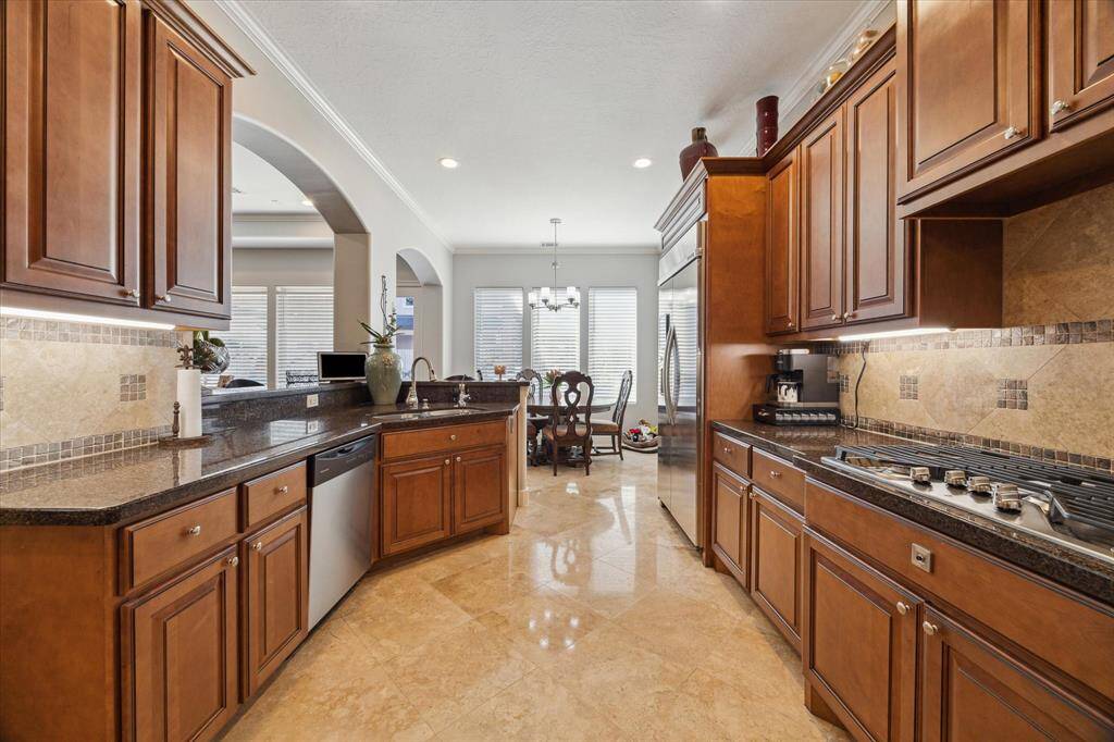 VIEW OF KITCHEN TOWARD BREAKFAST ROOM - handsome wood cabinets and great counter space for your culinary endeavors - gas cooktop with retractable downdraft vent, built-in refrigerator