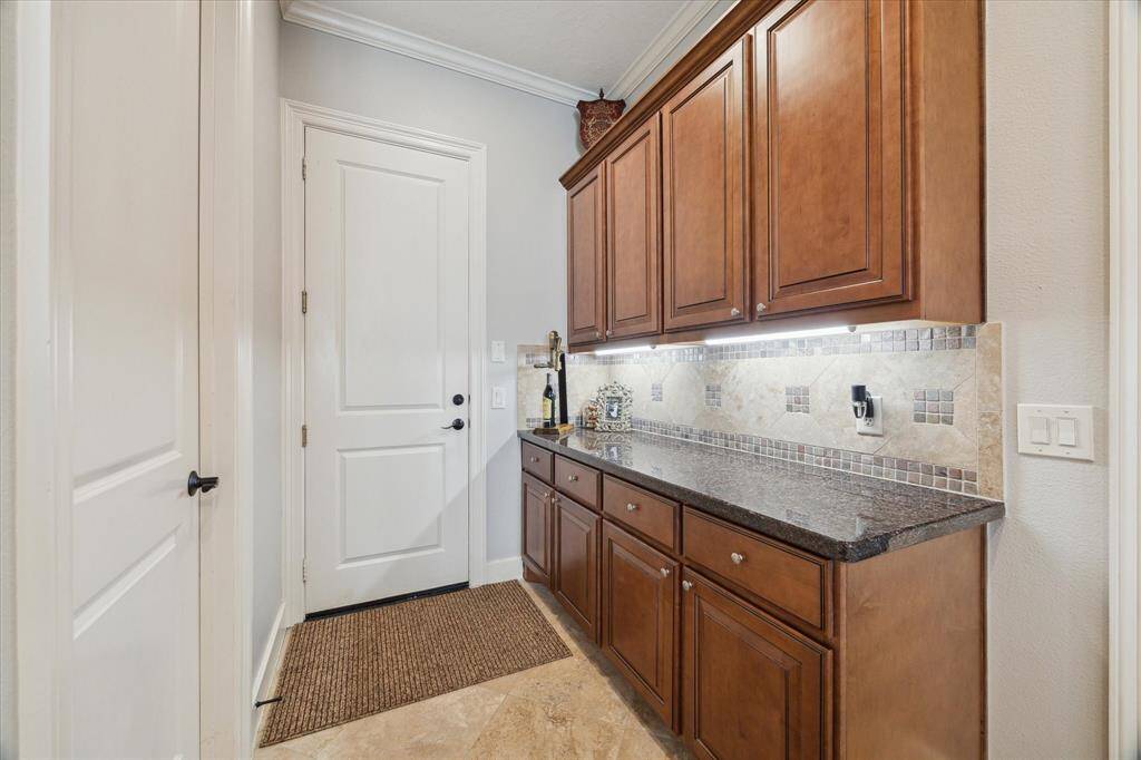 LARGE BUTLER'S PANTRY PROVIDES ADDITIONAL STORAGE AND SERVING SPACE - granite countertop and under-cabinet lighting