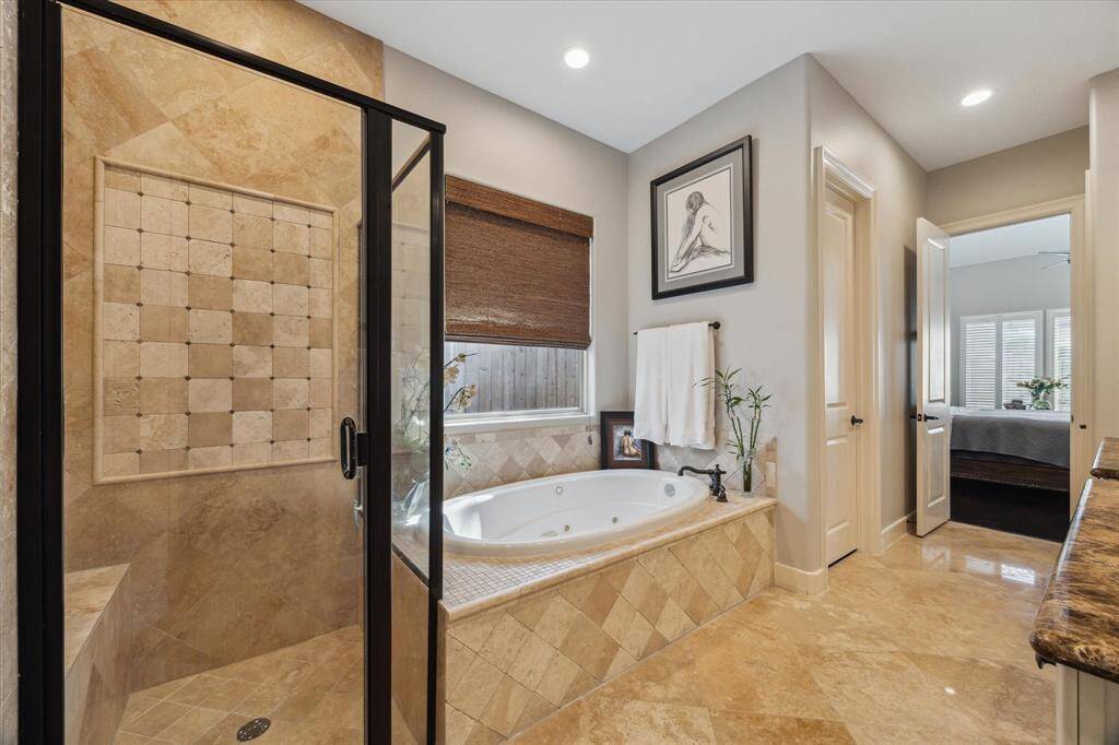 ANOTHER VIEW OF ENSUITE PRIMARY BATH - travertine flooring, full tile shower surround, seat in shower - 2 walk-in closets