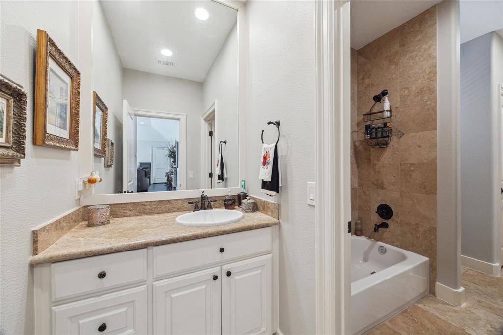 WELL-PLANNED HOLLYWOOD BATH UPSTAIRS - shared by 2 secondary bedrooms, travertine flooring, tub with shower