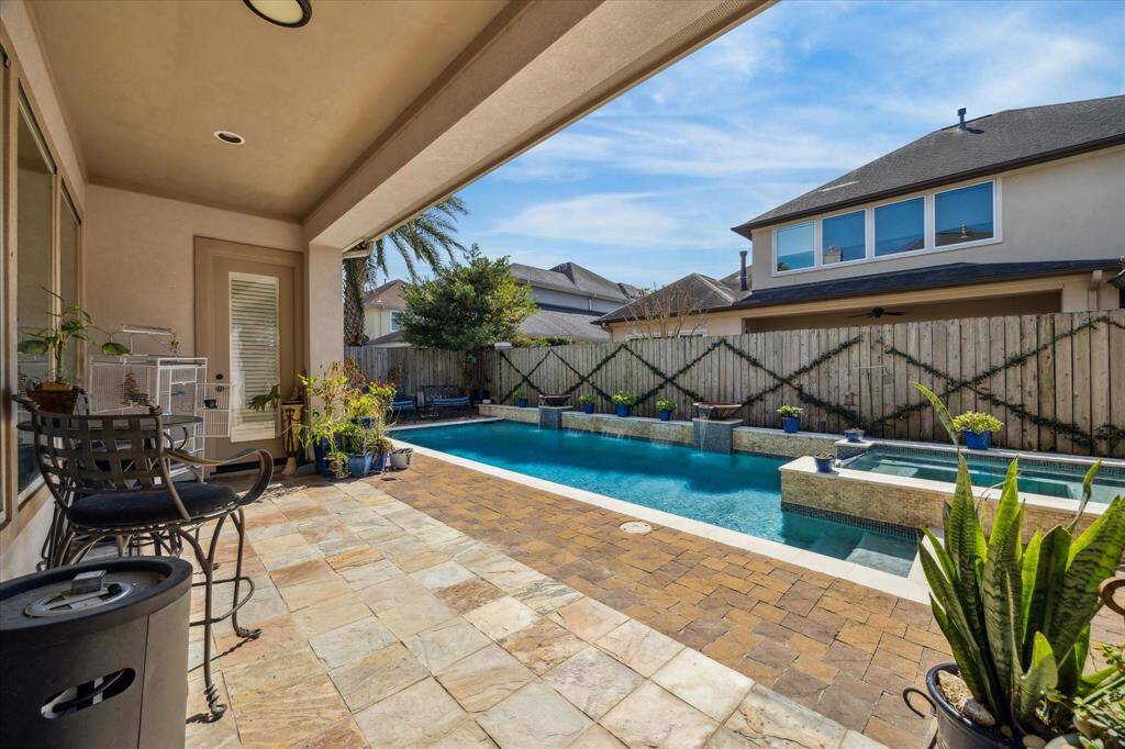 LARGE EXPANSE OF COVERED TERRACE OVERLOOKING POOL AND SPA