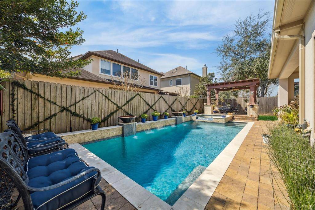 VIEW OF POOL AND SPA LOOKING TOWARD RAISED TERRACE WITH PERGOLA