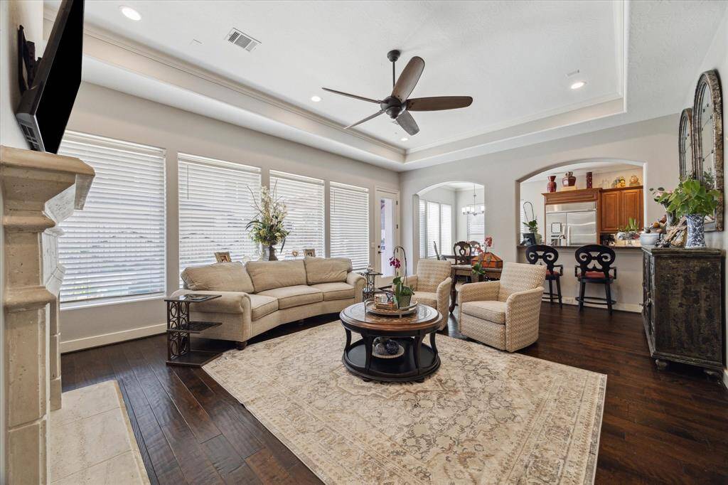SPACIOUS FAMILY ROOM FOR ENTERTAINING AND DAILY LIVING - handsome wide-plank wood flooring, tray ceiling with recessed lighting and ceiling fan - wall of windows overlooking the backyard pool/spa