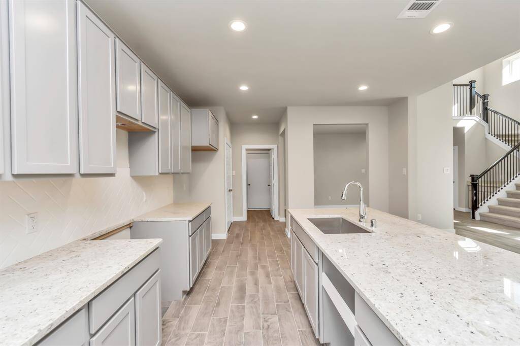 Discover another perspective of this exquisite kitchen, lavishly furnished with an ample expanse of counter space, offering tons of room for culinary creativity. Sample photo of completed home with similar floor plan. Actual colors and selections may vary.