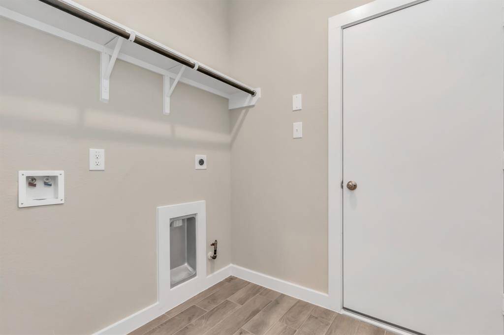 Located on first floor, a stylish laundry room where practicality meets a contemporary aesthetic. The dark finishes lend a sophisticated touch, creating a space that is both functional and visually appealing. Sample photo of completed home with similar floor plan. Actual colors and selections may vary.
