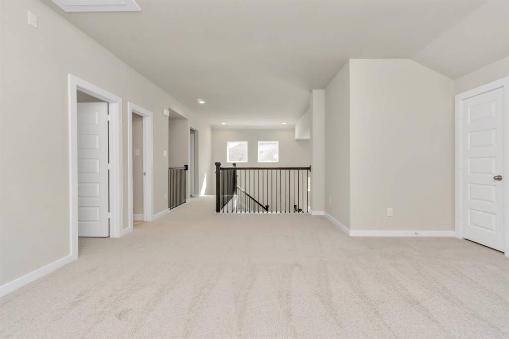 Come upstairs and relish a day of relaxation in this loft area! Ideal as an additional living space or game room, it boasts plush carpeting, high ceilings, custom paint, and windows that flood the area with abundant natural light. Sample photo of completed home with similar floor plan. Actual colors and selections may vary.