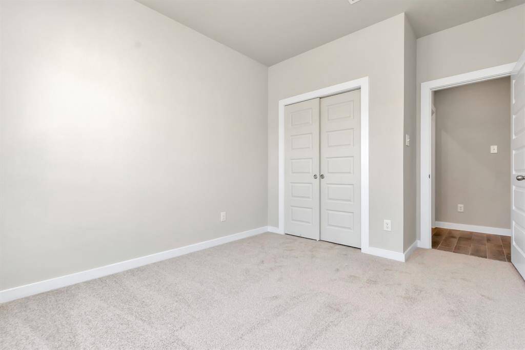 The welcoming guest suite, situated on the first floor is adorned with contemporary allure. The room boasts elegant 5-panel doors fitted with sleek, modern hardware, imparting a touch of sophistication. Indulge in the comfort of plush, fluffy carpet underfoot, while expansive windows flood the space with natural light.