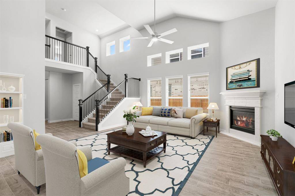 Bring your family and guests together in your delightful living room! Boasting lofty high ceilings, recessed lighting, a ceiling fan, custom paint, beautiful floors, and expansive windows that flood the space with ample natural light throughout the day.