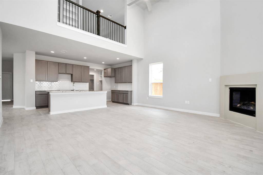 Bring your loved ones and guests together in the inviting living room! Boasting lofty high ceilings, recessed lighting, a stylish ceiling fan, custom paint, stunning flooring, and expansive windows that flood the space with ample natural light all day long. Sample photo of completed home with similar floor plan. As-built interior colors and selections may vary. Sample photo of completed home with similar floor plan. Actual colors and selections may vary.