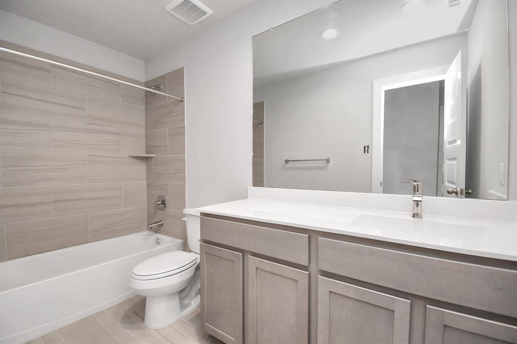 Indulge in refined charm in the secondary bathroom, where the tile flooring harmonizes with a bath/shower combo surrounded by tasteful tile. Slate wood cabinets, coupled with a gorgeous countertop, elevate the space, cultivating a truly welcoming atmosphere. Sample photo of completed home with similar floor plan. Actual colors and selections may vary.