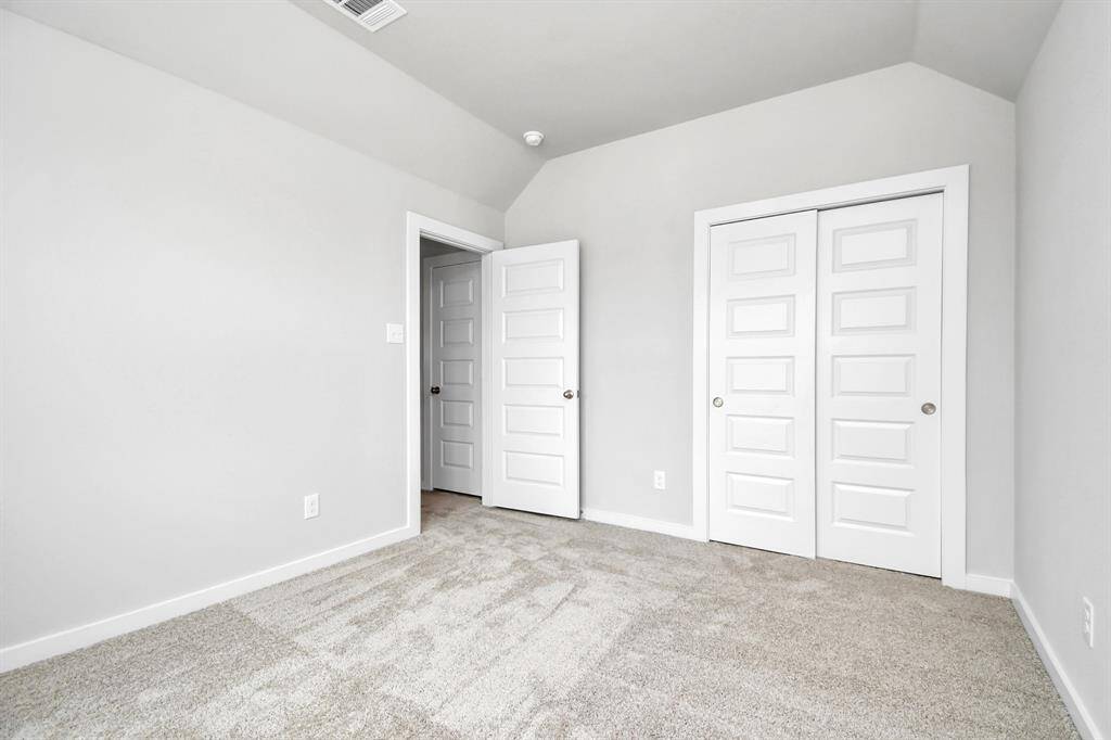 Secondary bedrooms showcase 5-panel doors adorned with modern hardware, large windows enhanced by privacy blinds, and spacious closets featuring sleek and contemporary finishes. Sample photo of completed home with similar floor plan. Actual colors and selections may vary.