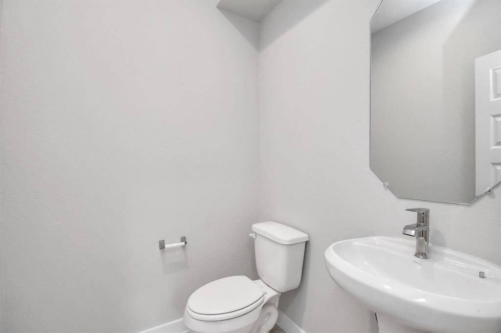 Meet the half bath and wide stair access across from the dedicated home office. Sample photo of completed home with similar floor plan. Actual colors and selections may vary.