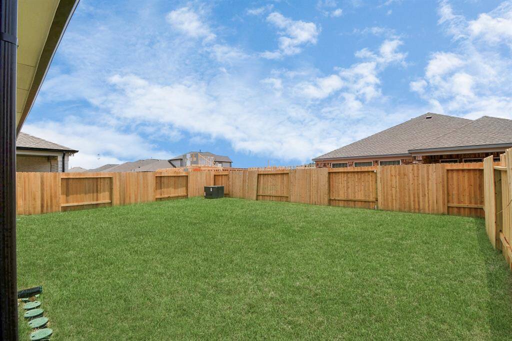 Discover the charm of this spacious backyard featuring a delightful covered patio. With ample room for both play and relaxation, it's the perfect outdoor haven. Tailor this space to your liking with patio furniture, a BBQ pit, and more. The potential for creating your dream outdoor living area is limitless!