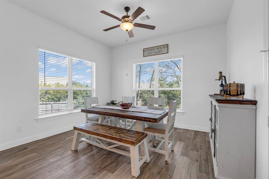 Adjacent to the kitchen is a spacious breakfast area, bathed in natural light from large windows that frame stunning views of the wooded backyard. This serene setting provides the perfect backdrop for morning coffee or casual family meals, offering a tranquil escape right at home.