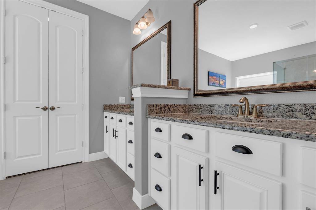 Large mirrors above each vanity enhance the sense of space and light, creating an airy and inviting atmosphere.