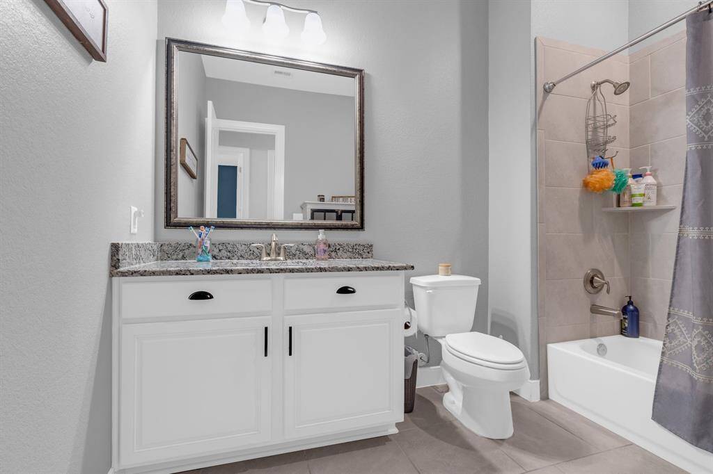 The bathroom is equipped with a combination shower and bathtub, providing flexibility for both quick showers and relaxing baths.