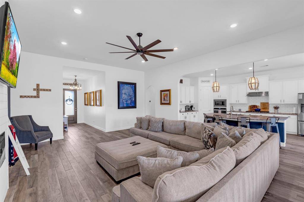 Natural light floods the space through large windows, highlighting the open-concept design that makes this area perfect for both entertaining and everyday living.